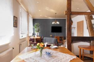 a dining room with a table with a vase of flowers on it at Ferienwohnung Ruhezone in Gardelegen
