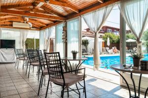 a patio with tables and chairs and a swimming pool at Marketos studio 2 in Kefallonia +12 photos