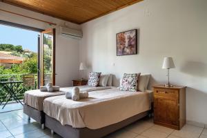 a bedroom with a large bed and a balcony at Marketos studio 2 in Kefallonia
