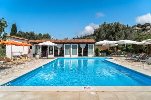 a swimming pool in front of a villa at Marketos studio 2 in Kefallonia