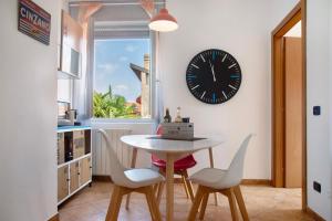 a dining room with a table and a clock on the wall at La Piazzetta in Germignaga