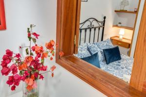 a vase with flowers in front of a mirror at Casa Paco in Mogán