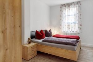a bedroom with a bed with red pillows on it at Jogis Ferienwohnungen in Freiburg im Breisgau