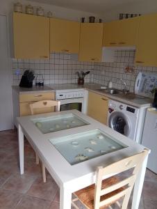eine Küche mit einem weißen Tisch und einer Spüle in der Unterkunft Tiny Cantalou in Saint-Martin-sous-Vigouroux + 4 Fotos