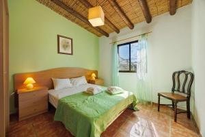 a bedroom with a bed and a chair and a window at Quinta da Amendoeira in Foz +67 photos