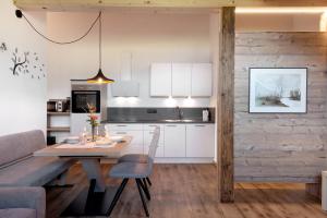 a kitchen and dining room with a table and a couch at Living Lerchna - Schöne Aussicht in Maranza