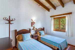 a bedroom with two beds and a window at Sa Carbona in Artá +17 photos