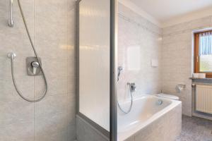 a bathroom with a shower and a bath tub at Mayr Apartments sechs in Plaus +18 photos