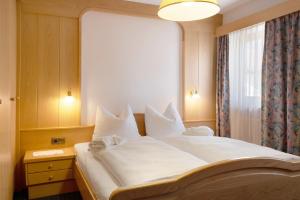 a bedroom with a large white bed with a window at Mayr Apartments sechs in Plaus