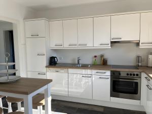 a kitchen with white cabinets and a wooden table at Haus Blumenglück in Herscheid