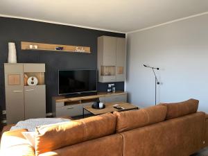 a living room with a couch and a flat screen tv at Haus Blumenglück in Herscheid