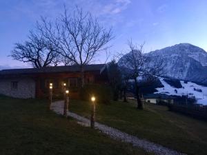 a house with lights in front of a mountain at Jagdhütte in Abtenau