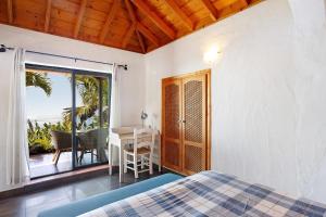 a bedroom with a bed and a table and a balcony at Las Vetas in Tijarafe +18 photos