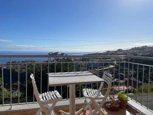 a table and chairs on a balcony with a view of the ocean at Apartamento Jade in Caniço