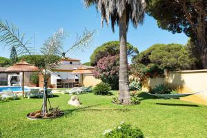 a yard with a hammock and a house at Magnolia A - Solo Familias in Conil de la Frontera