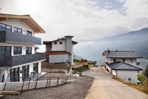 a winding road between two buildings with mountains in the background at Apart Mountainview in Rohrberg