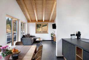 a kitchen and living room with a wooden ceiling at Apart Mountainview in Rohrberg +32 photos