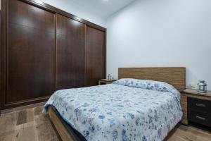 a bedroom with a large bed and a wooden wall at Finca Aramai in Adeje +16 photos