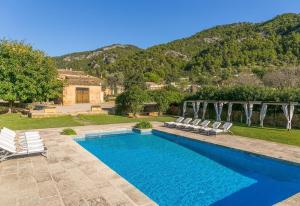 a swimming pool with chairs and a house at Historic Finca in Mallorca Up To 8 in Andratx