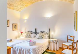 two beds in a white room with two chairs at Historic Finca in Mallorca Up To 8 in Andratx +45 photos