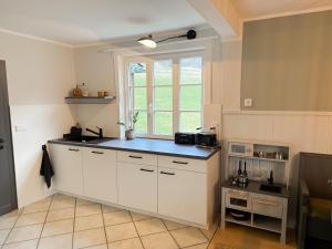 a kitchen with white cabinets and a window at Ferienhaus Hallmanns Hof in Schmallenberg