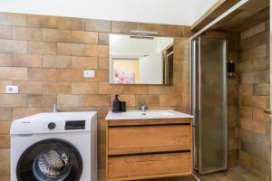 a bathroom with a washing machine and a sink at Casa donna Sofia in Specchia +13 photos