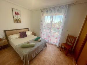 a bedroom with a bed and a chair and a window at Relax Inn in Pilar de la Horadada +10 photos