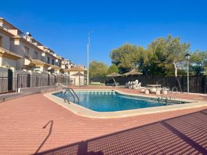 a swimming pool in front of a house at Relax Inn in Pilar de la Horadada