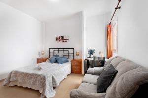 a living room with a bed and a couch at Alcamar in Alcalá