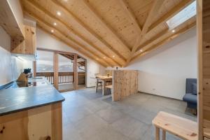 a kitchen and dining room with a wooden ceiling at Parliflhof Apt Langfenn in Meltina
