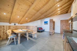 a kitchen with wooden walls and a wooden table and chairs at Parliflhof Apt Langfenn in Meltina +26 photos
