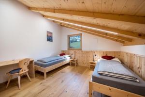 two beds in a room with wooden walls at Parliflhof Apt Langfenn in Meltina