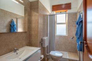 a bathroom with a sink and a toilet and a window at Casa Ginevra Salento in San Cassiano +14 photos