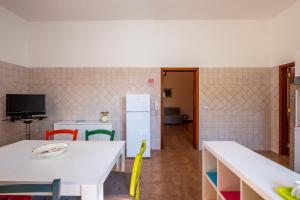 a kitchen with a white table and a refrigerator at Casa Ginevra Salento in San Cassiano