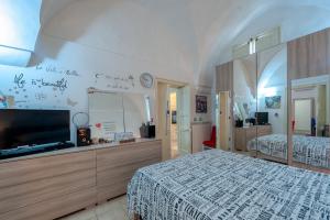 a bedroom with two beds and a flat screen tv at Dimora storica monteroni di lecce in Monteroni di Lecce