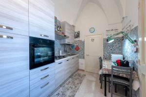 a kitchen with white cabinets and a table in it at Dimora storica monteroni di lecce in Monteroni di Lecce