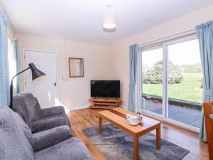 a living room with a couch and a tv and a table at The Turbles - Swallows Nest in Castlemorton