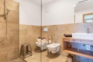 a bathroom with a toilet and a sink and a shower at Living Lerchna -Apartment Morgentau in Maranza +22 photos