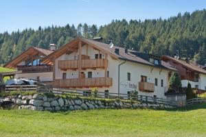 a large white house with a fence in a field at Living Lerchna -Apartment Morgentau in Maranza