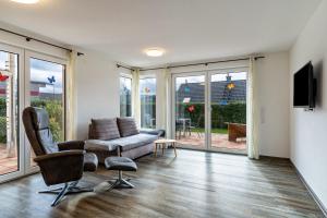 a living room with a couch and chairs and sliding glass doors at Ferienwohnungen Kapellenblick in Biederbach Baden-Württemberg
