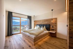 a bedroom with a bed and a large window at Leierhof Karlotta in Rodengo +37 photos