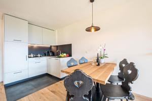 a kitchen and dining room with a wooden table and chairs at Leierhof Karlotta in Rodengo