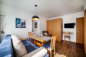 a living room with a table and a dining room at Schnitzer Ferienwohnung Enzian in Rablà