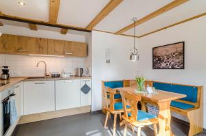 a kitchen and dining room with a wooden table and chairs at Schienerberghütte in Öhningen +17 photos