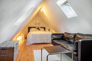 a living room with a bed and a leather couch at Backhaus in Groß Wokern