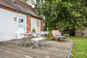a patio with a table and chairs on a wooden deck at Backhaus in Groß Wokern