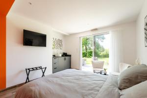 a bedroom with a bed and a tv on the wall at Kerwall - Maison d'hôtes in Malville +46 photos