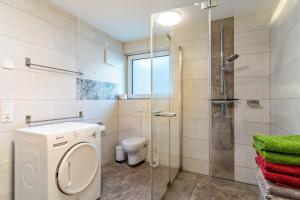 a bathroom with a toilet and a glass shower at Ferienwohnungen Kapellenblick in Biederbach Baden-Württemberg +50 photos