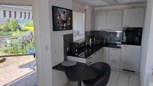 a kitchen with white cabinets and a black table at Ferienwohnung Rheinblick in Küssaberg