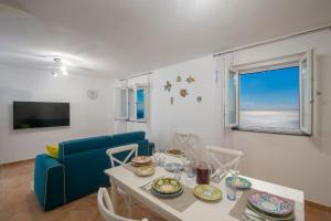 a living room with a table and a blue couch at Villa Domus Augusto in Conca dei Marini